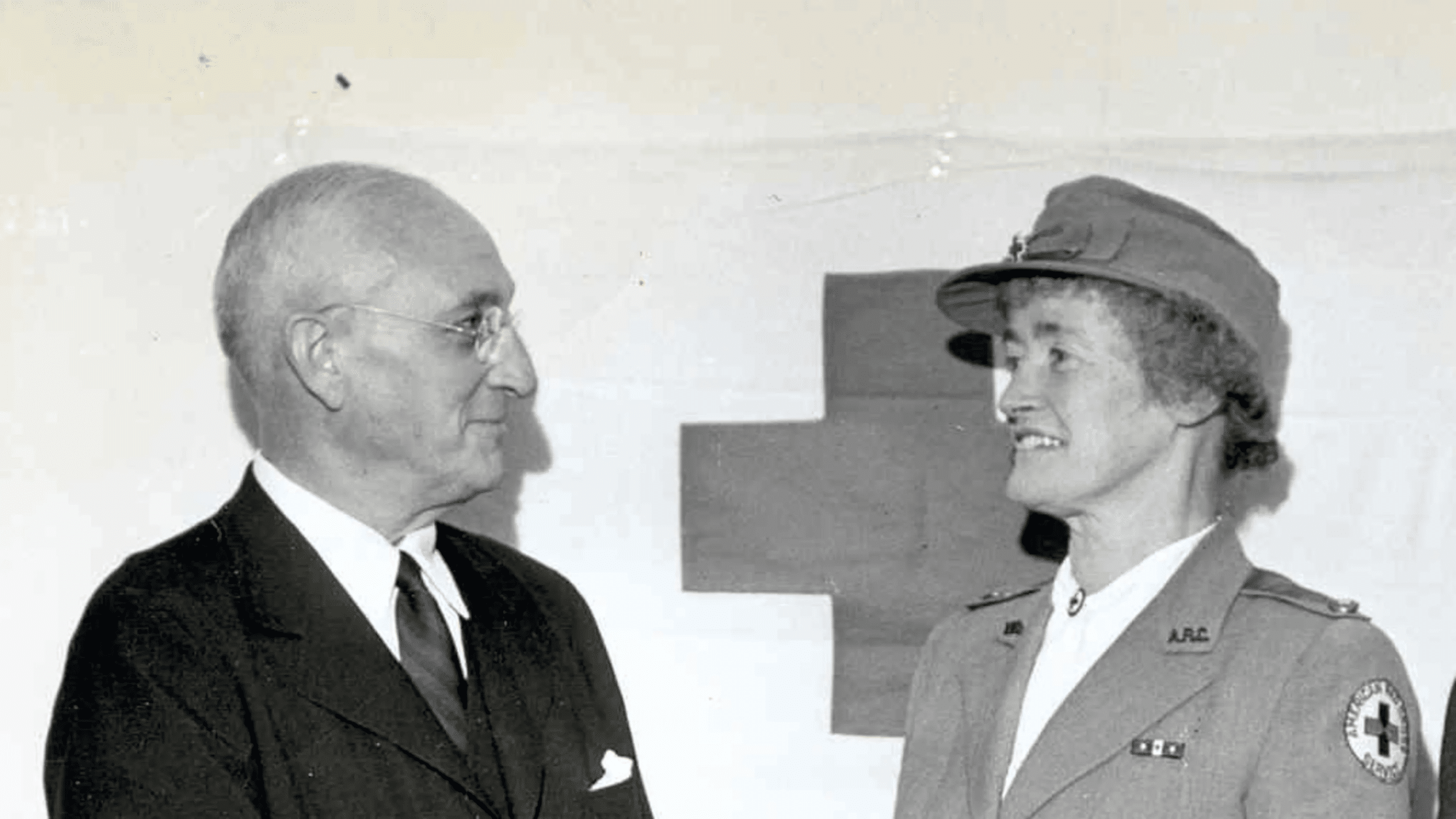 An old photo of a man and woman standing next to each other.