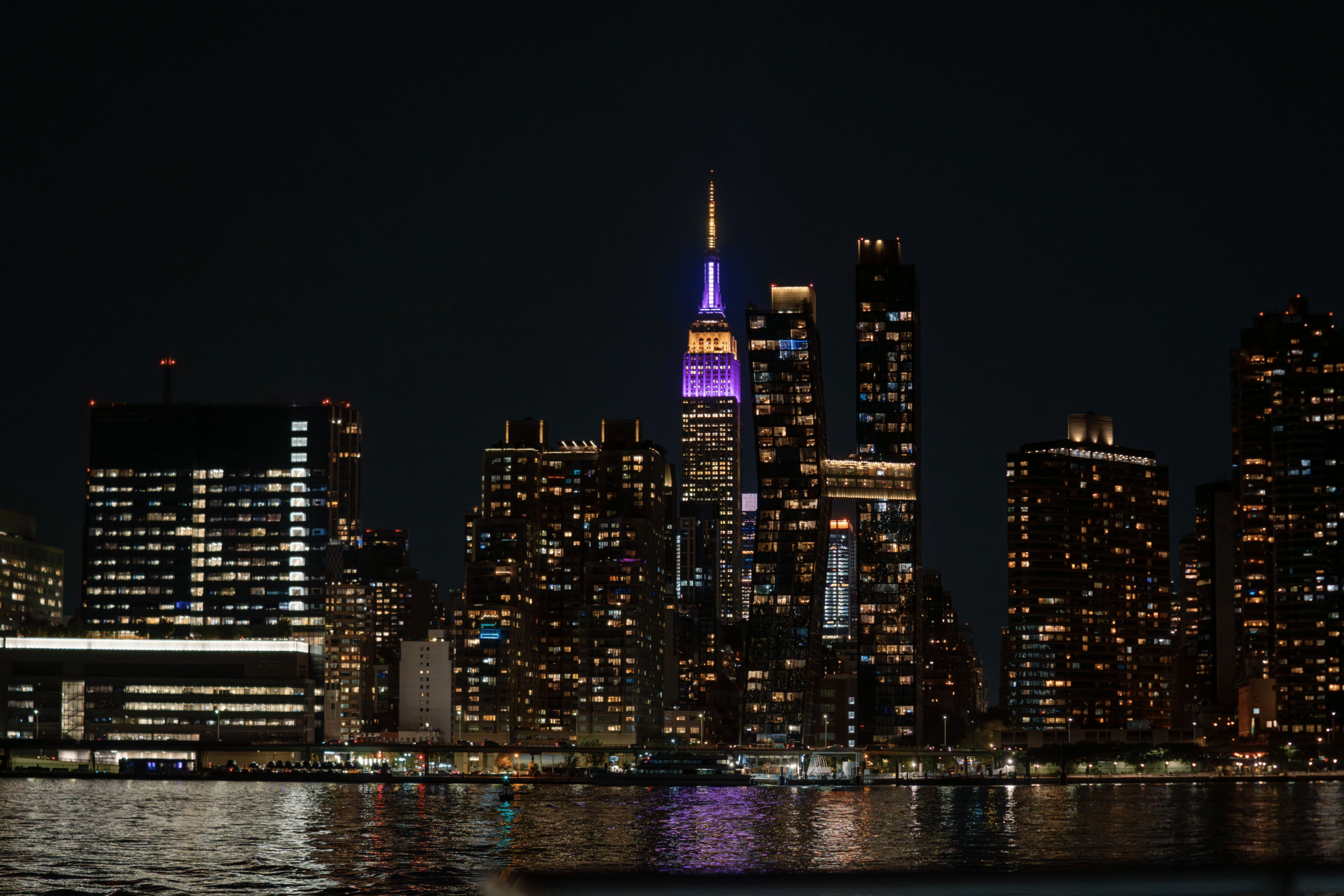 The empire state building is illuminated at night, showcasing the immense community support.