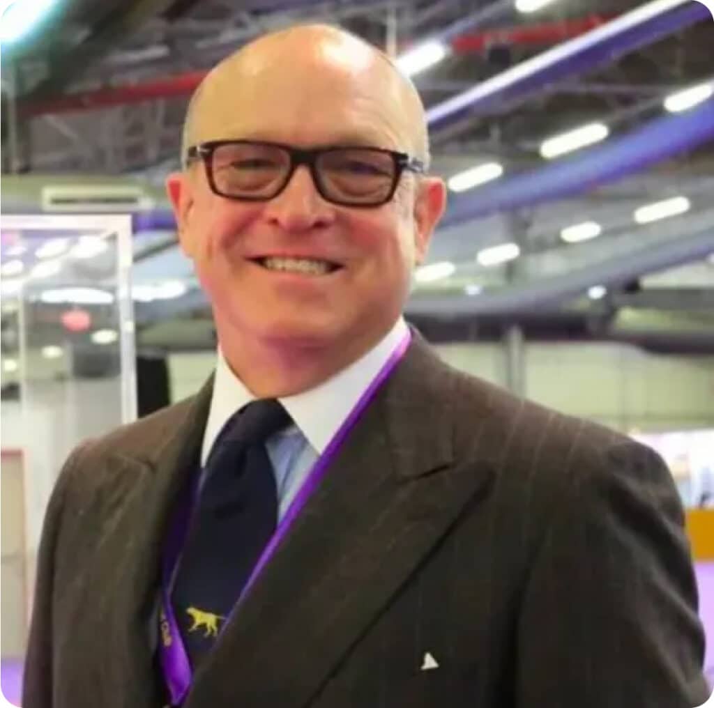 A man in a suit and tie smiles for the camera.